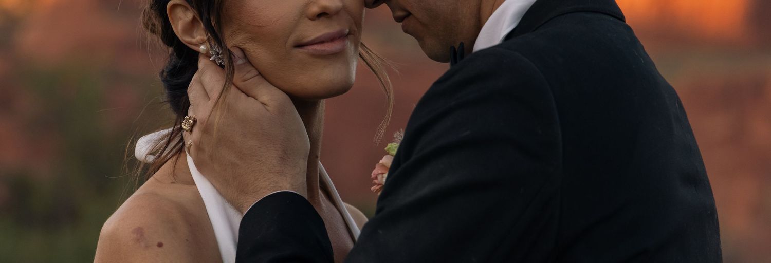 Romantic moment between couple in wedding attire during golden hour sunset.