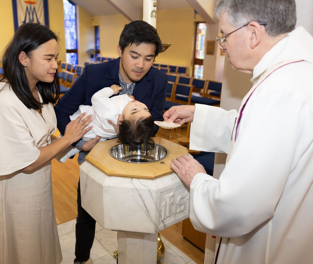 Medical students in white coats practice clinical skills and procedures in a training lab setting.
