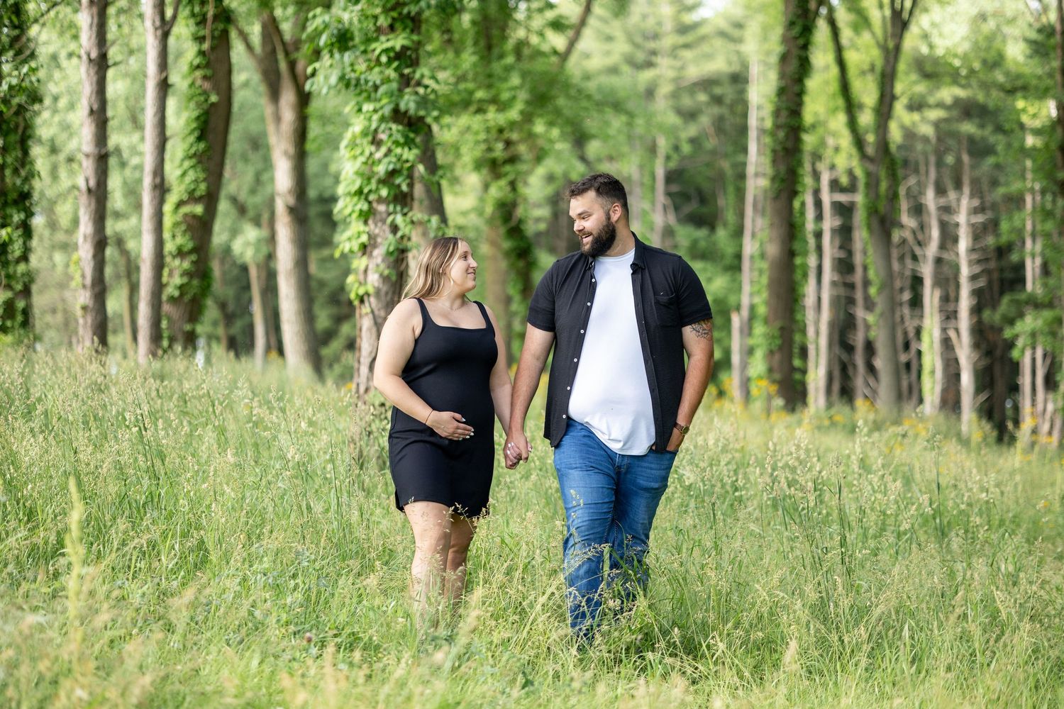 Springfield, IL motherhood photographer captures an expecting couple in a field of tall grass in Central Il