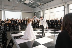 Wedding reception setup in a bright modern venue with black and white decor.
