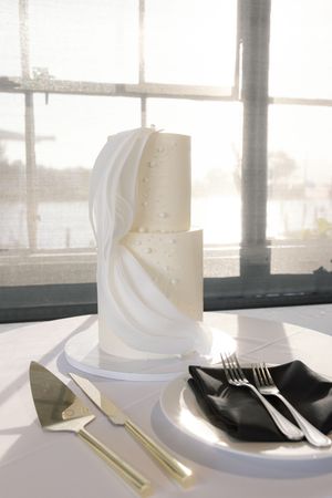 Elegant white napkins and place settings arranged on table near bright window.
