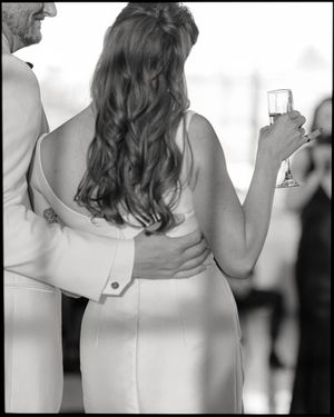 A black and white photograph showing the back detail of a formal dress at an event.