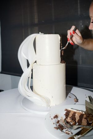 A sequence of photos showing a three-tier white wedding cake being demolished piece by piece on a surface.
