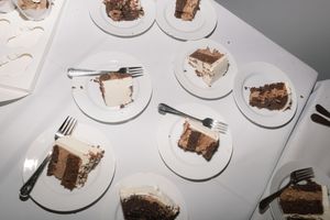 Overhead view of partially eaten chocolate cake slices on white plates at a wedding reception.