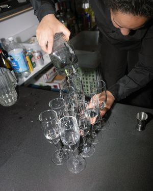 Wine glasses being arranged on a dark surface at an elegant event.
