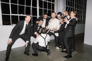 Wedding guests in black and white attire dancing at a lively reception.