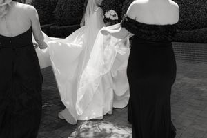 Wedding guests dancing at reception in formal black and white attire.