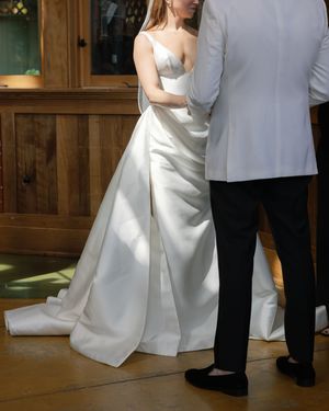 Bride and groom share intimate dance moment in rustic wooden venue.