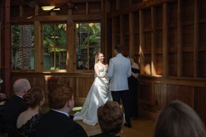 Natural light streams through wooden beams at rustic wedding venue. Sunnyside conservatory in San Francisco wedding ceremony