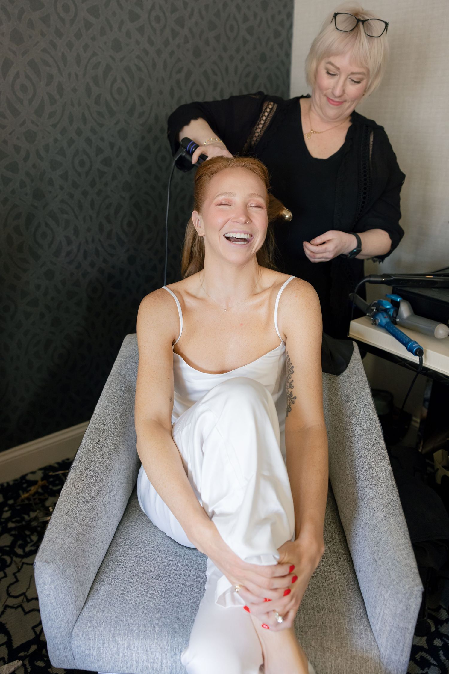 Candid sequence of a person getting ready in a grey armchair with laughter and joy.