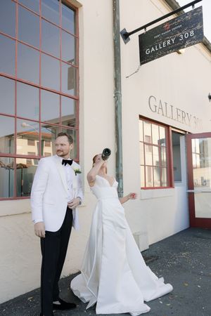 A couple in wedding attire poses outside Gallery 308 on their special day.