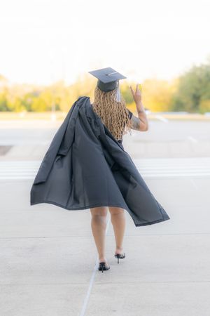 A sequence of photos showing someone twirling in a black coat and white knee socks on a concrete surface at sunset.