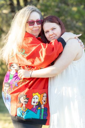 A sequence of four photos showing two people hugging while wearing colorful clothing in an outdoor setting.