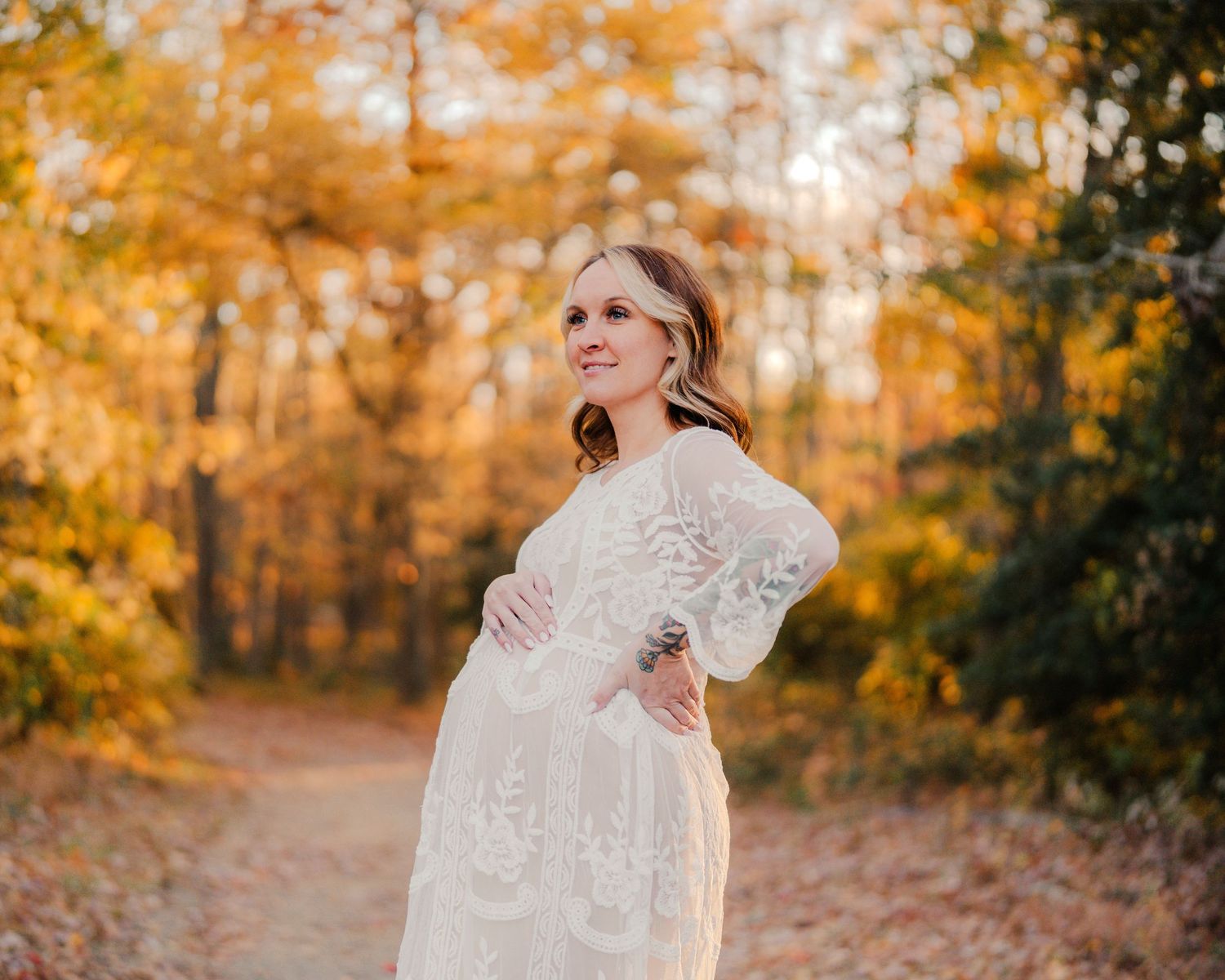 A couple in autumn woods share intimate moments as fallen leaves create a romantic setting in the forest.