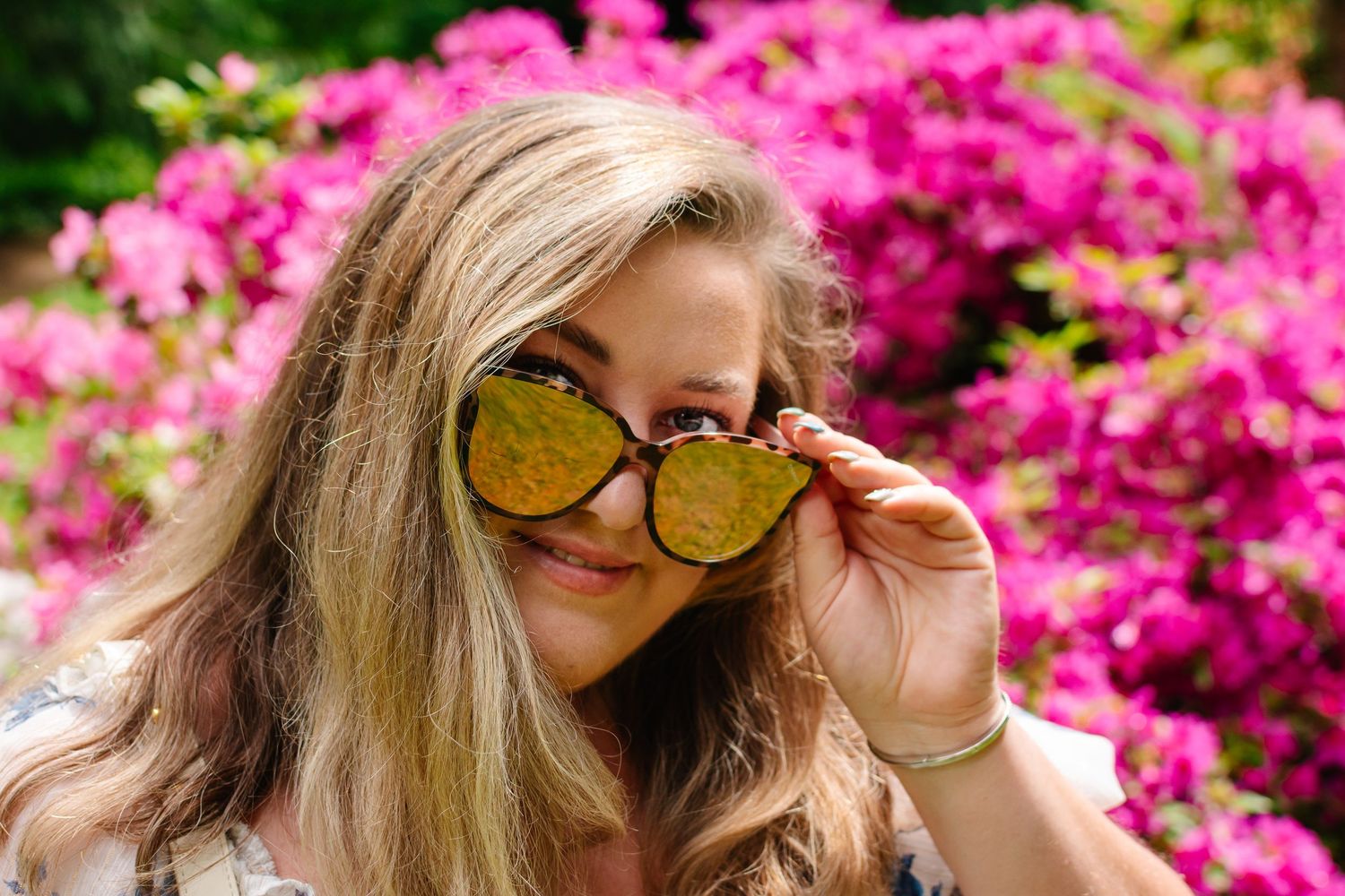 Branding photo at Seattle Arboretum – playful pose with sunglasses in front of vibrant spring blooms.