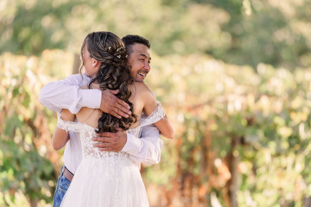 Couple embraces during their outdoor wedding photoshoot in natural lighting.