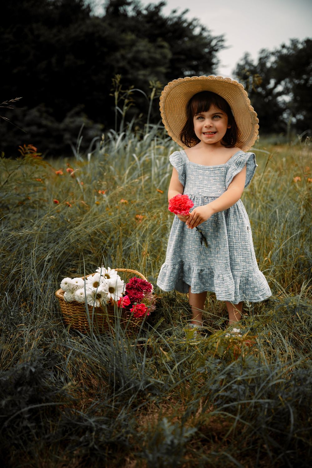 spring portrait session with toddler holding flowers in a field of grass in Fort Worth, Texas