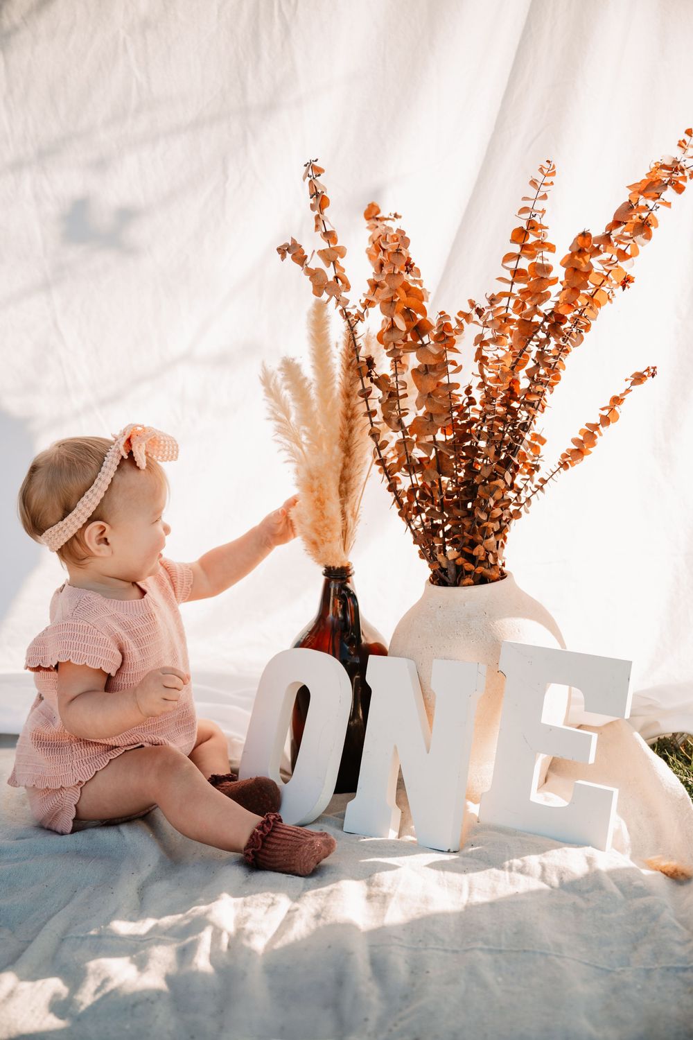 boho cake smash session with one year old baby girl and pampas grass