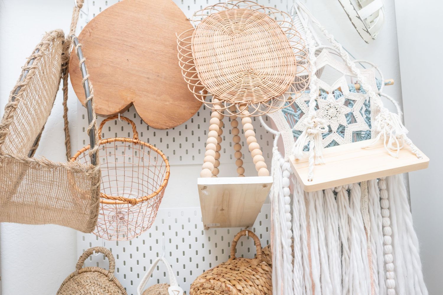 Collection of woven baskets and textiles in neutral tones displayed on retail shelving.