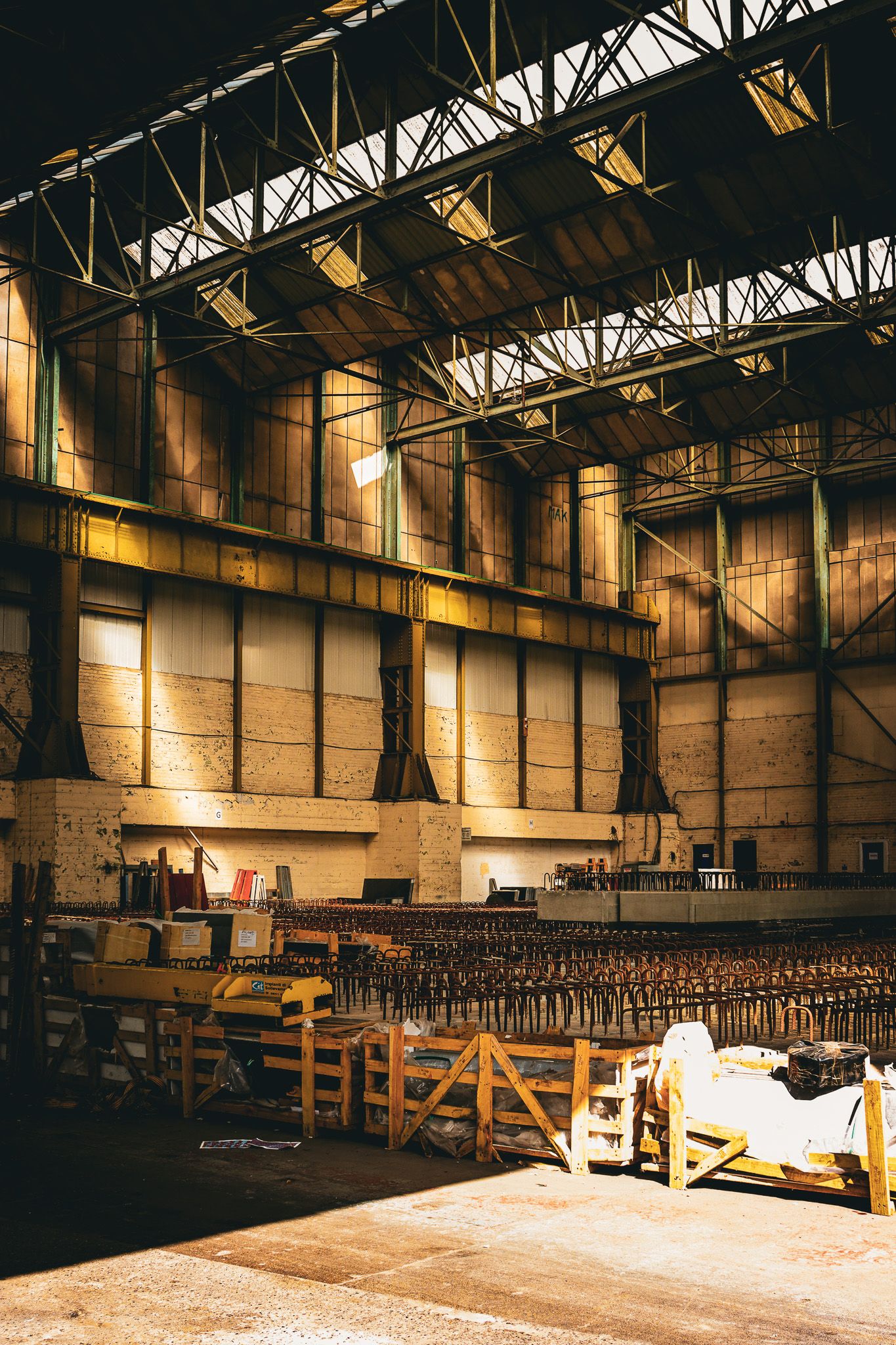 Interior of an empty industrial warehouse with soft golden light and exposed metal beams. Brightside, Sheffield