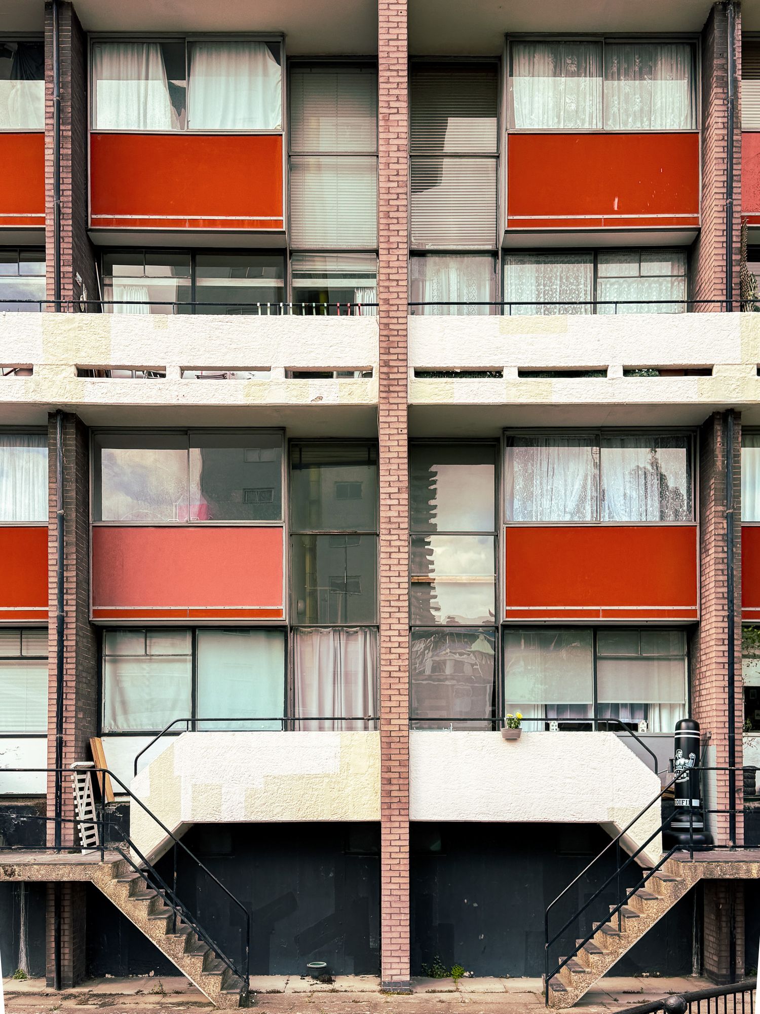 Golden lane estate. Close-up of red balconies and patterned windows on a modernist housing block.