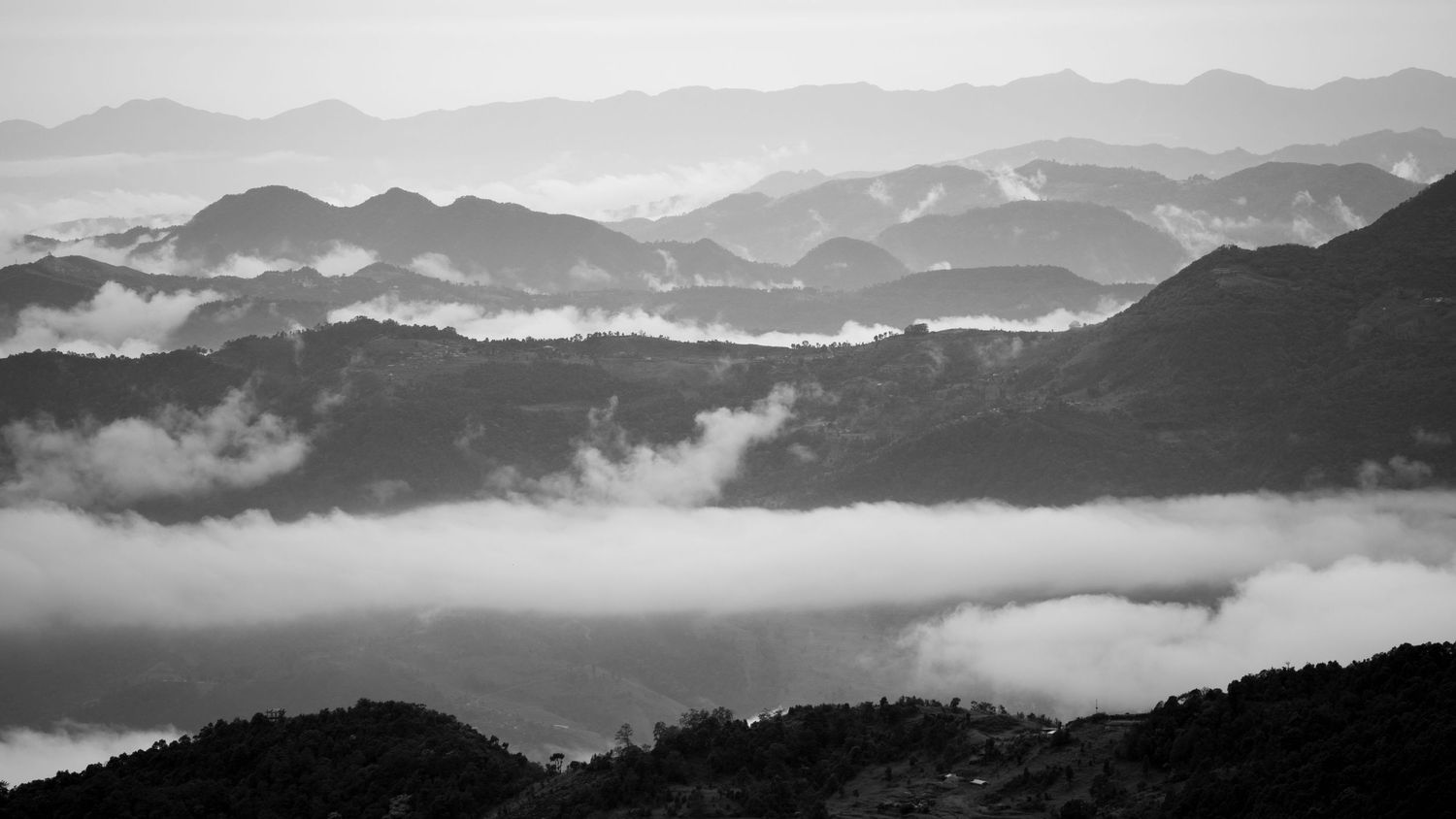 Dramatic mountain range with layers of misty peaks fading into the distance.