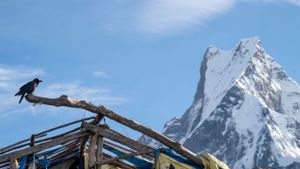 Majestic view of Mount Everest's peak rising above surrounding mountains in the Himalayas.