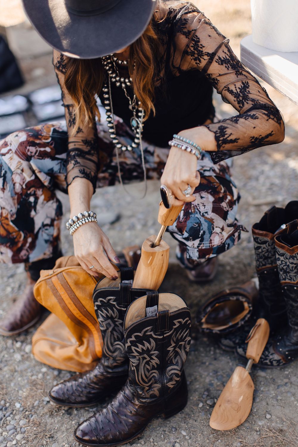 Western boots and accessories with lace dress showing bohemian cowgirl fashion styling.
