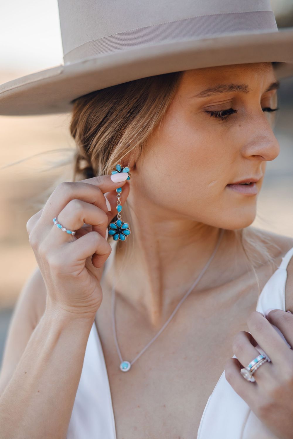 Elegant western style outfit featuring turquoise jewelry and light cowboy hat.