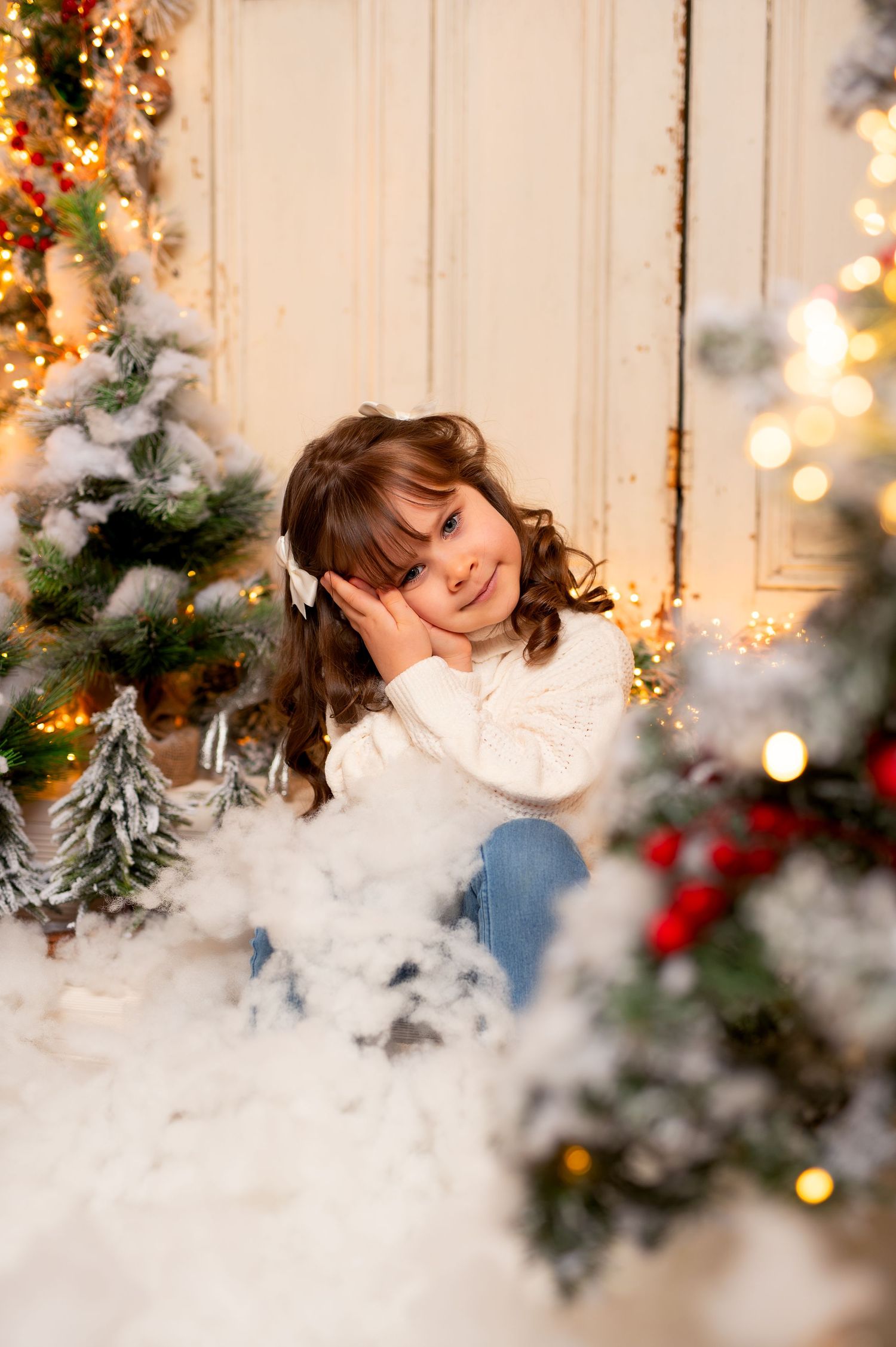 Candid family moment captured during holiday photo session with Christmas decorations and warm lighting.