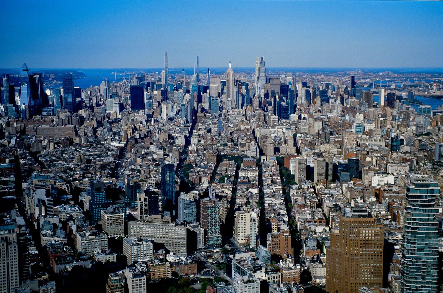 Panoramic aerial view of Manhattan skyline showing dense urban development and iconic architecture.