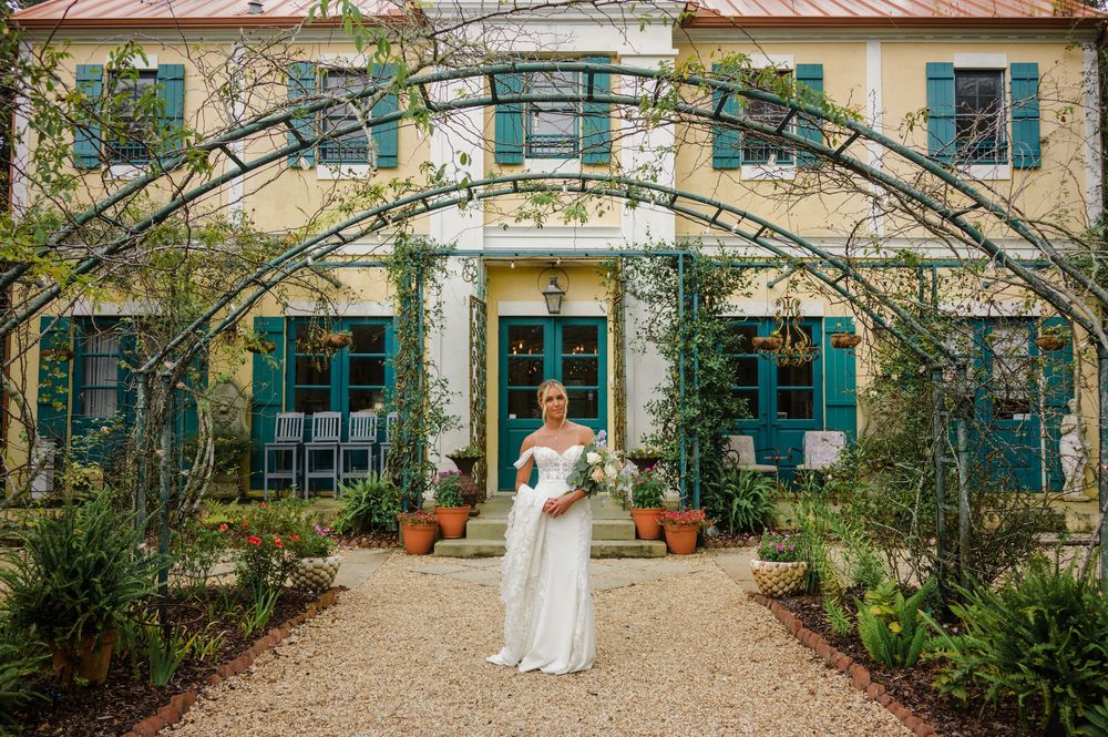 A classical European-style villa with turquoise shutters and climbing vines creates a romantic wedding backdrop.