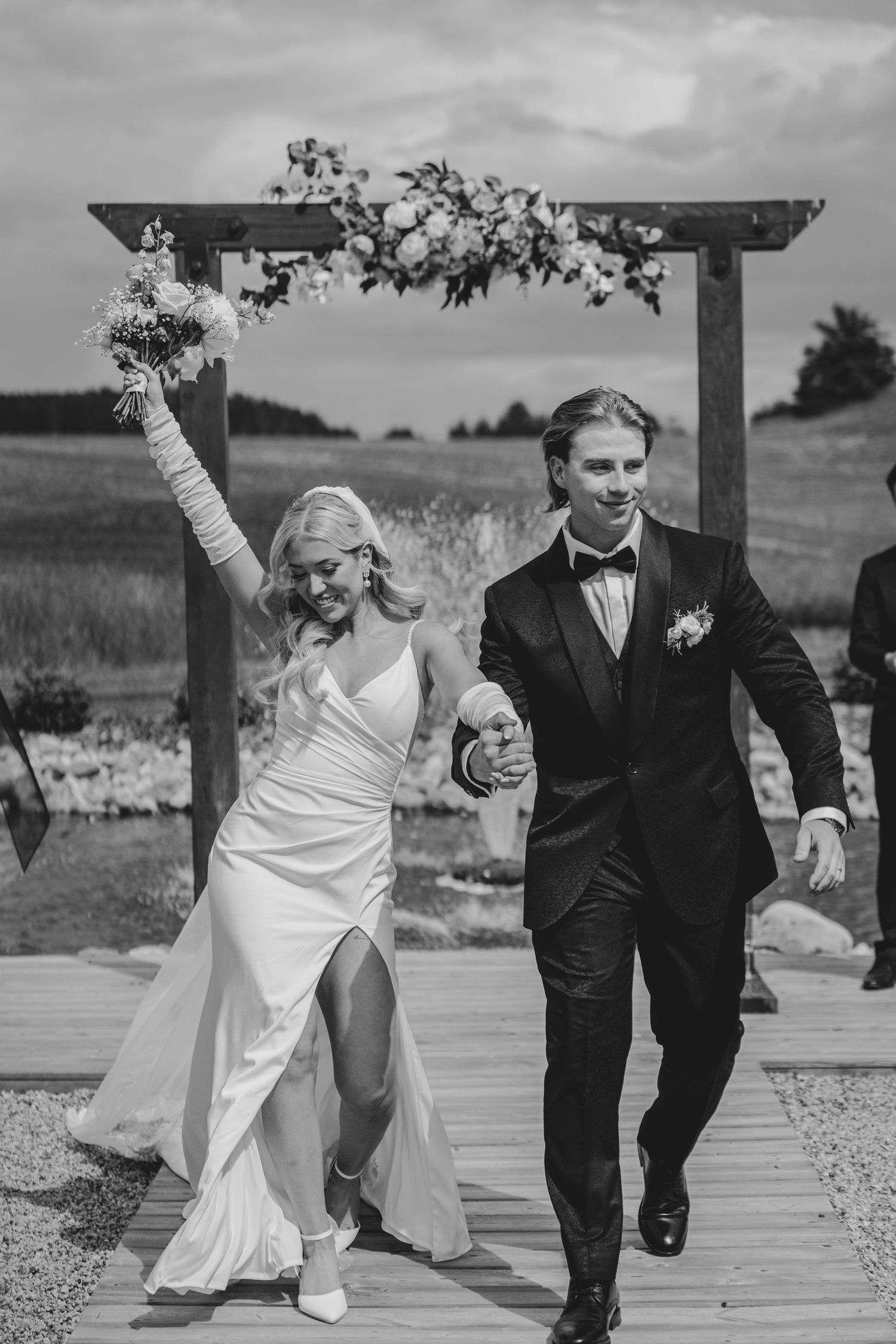 A joyful wedding couple dances and celebrate together in a sequence of candid black and white photos outdoors.