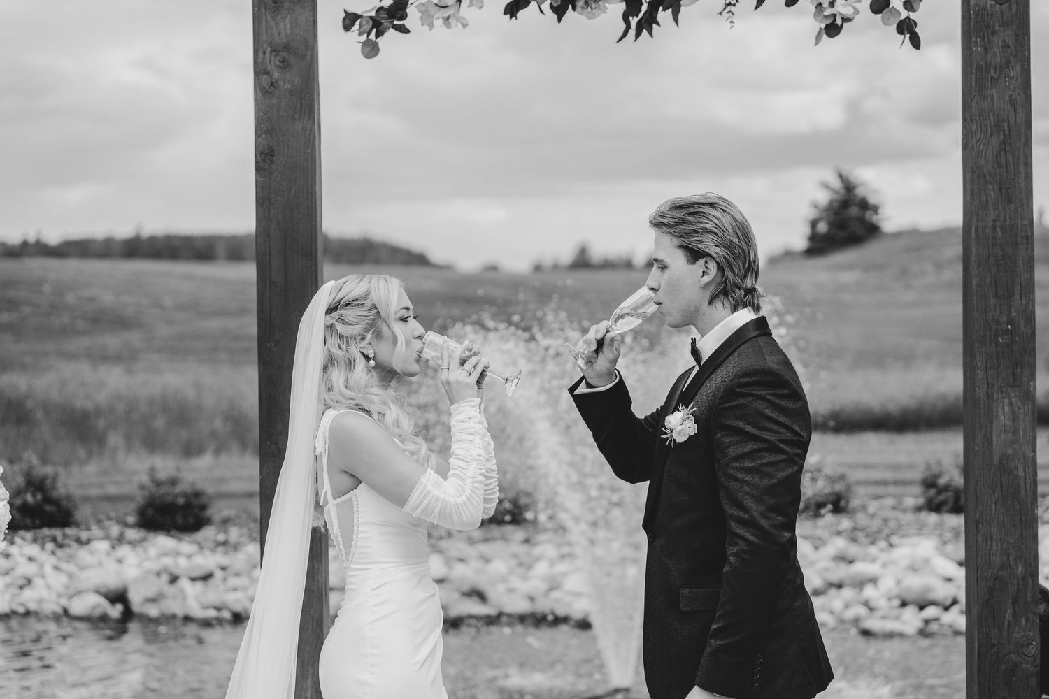 A couple shares an intimate moment during their wedding photoshoot in a rustic outdoor setting.
