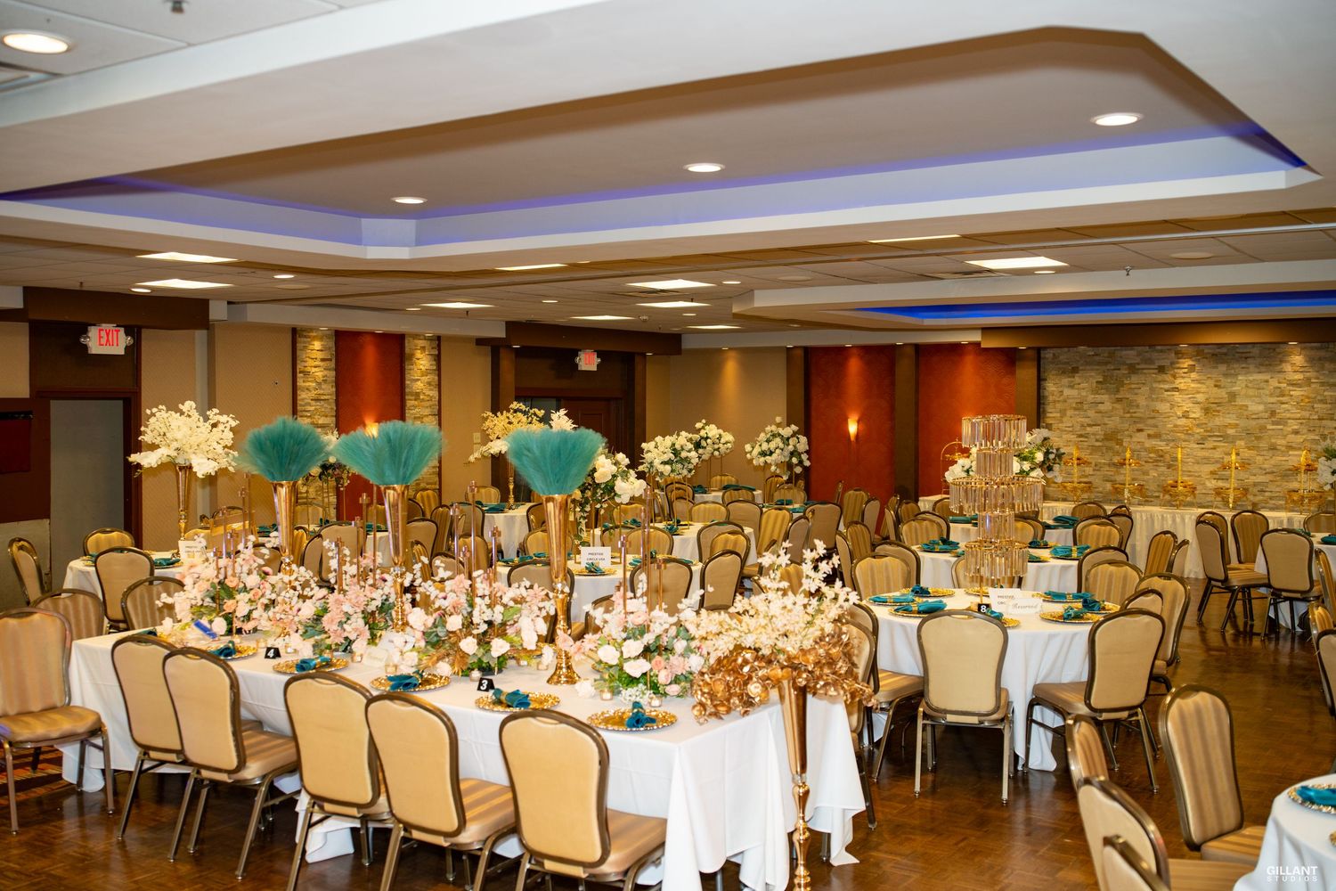 Elegant banquet hall setup with round tables, white linens, and warm lighting for a formal event.