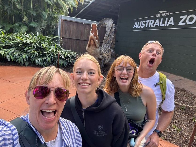 Smiling friends gathered at an Australian sports venue for a fun outing.