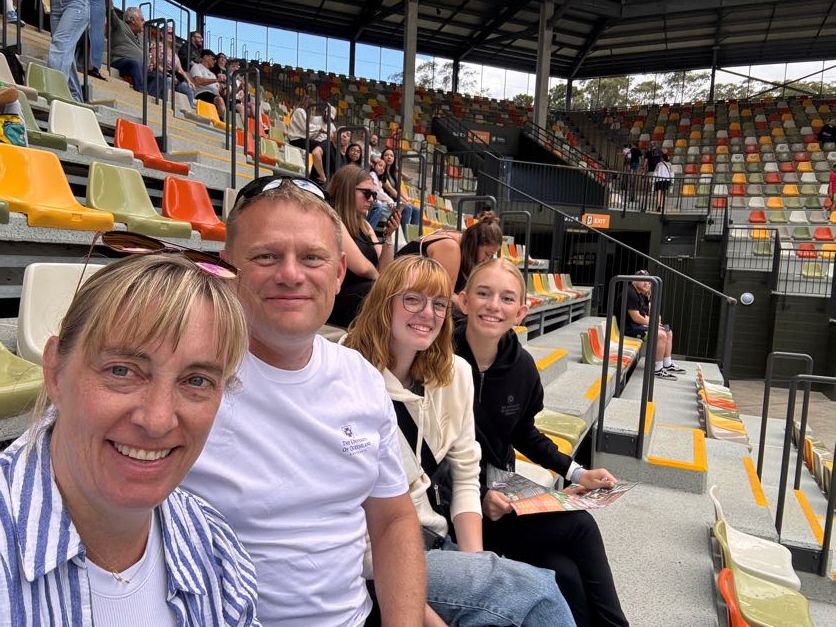 A group of spectators enjoying an outdoor sporting event at a stadium.