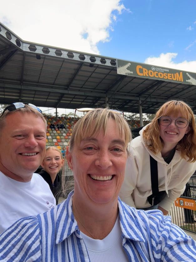 People enjoying themselves in the stadium seats on a sunny day with blue skies.