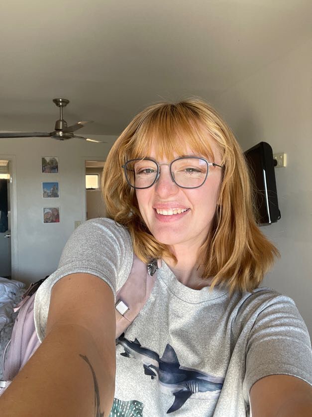 Someone taking selfies in casual grey clothing at home.