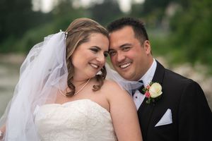 A newlywed couple shares intimate moments during their wedding day photo session in a garden setting.