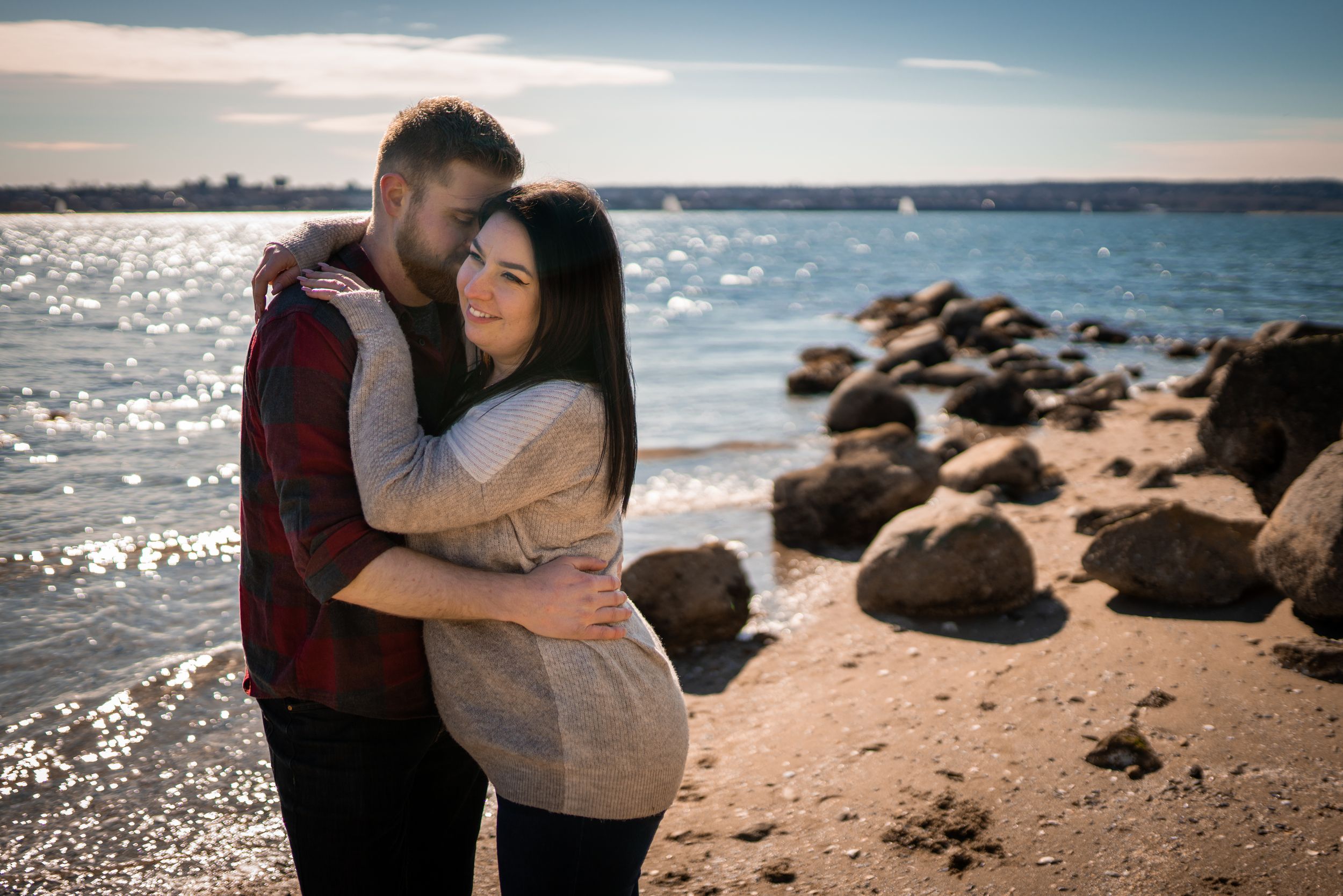 A series of romantic beach photographs showing couples embracing and walking along a rocky seashore at sunset.
