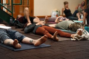 People lying on yoga mats during a relaxation session indoors.