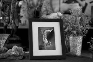 Black and white framed photograph displayed among flowers and decorative items.