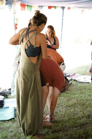Attendees in casual attire interacting during an outdoor festival event under a tent.