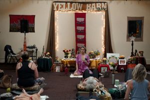 A group meditation session at Yellow Barn with altar and string lights creating a peaceful atmosphere.