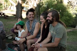 A group of friends laughing and enjoying time together outdoors on a sunny day.