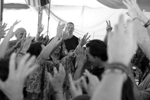 Black and white photo of raised hands during an energetic crowd gathering.