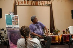 A small indoor performance space with Yellow Barn signage and musical instruments visible.
