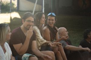 People sitting together outdoors in casual summer attire during a social gathering.