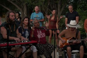 Musicians playing keyboard and guitar at an outdoor gathering.